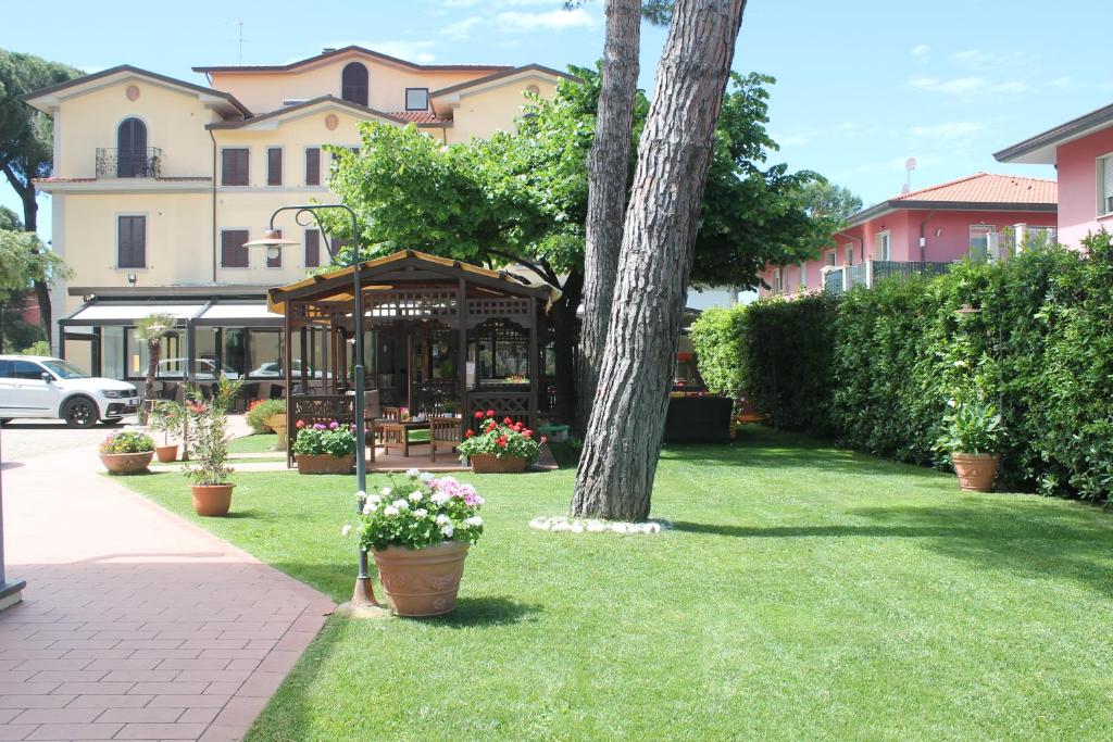 a garden with a tree and a gazebo at Hotel Virginia in Marina di Massa