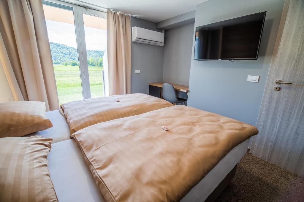 Habitación de hotel con 2 camas y ventana grande en Guesthouse Mars, en Ig