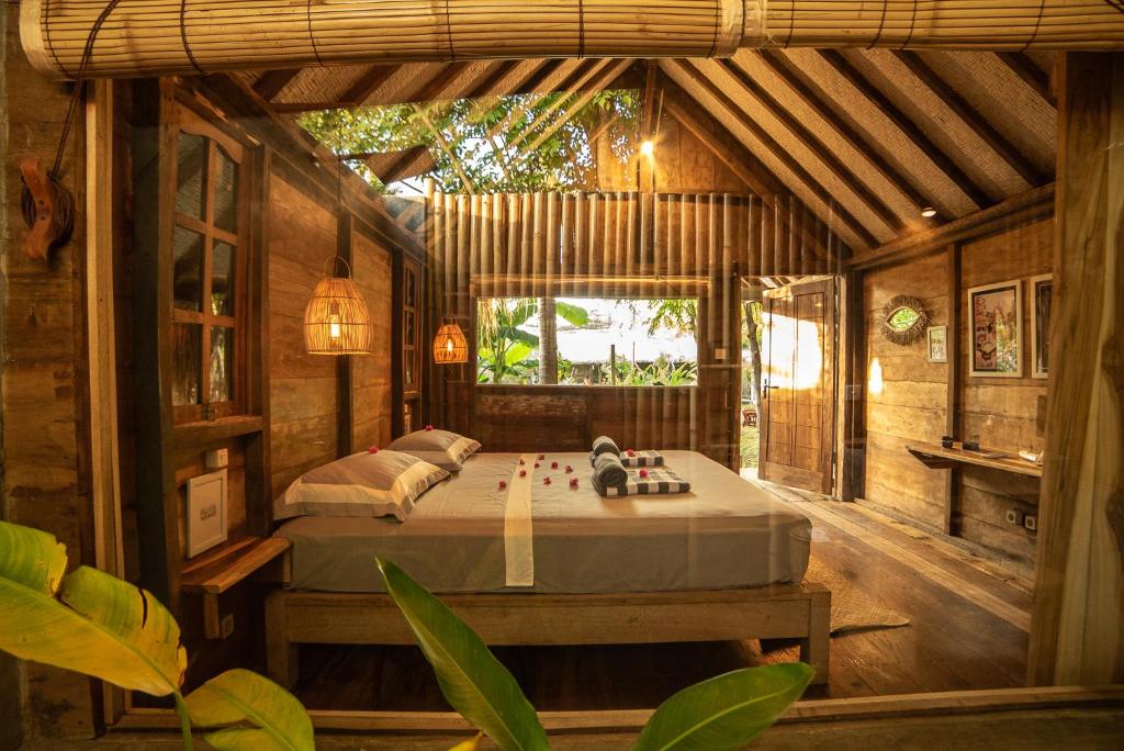 a bedroom with a bed in a wooden house at Musa Villas and Bungalows Gili Air in Gili Air