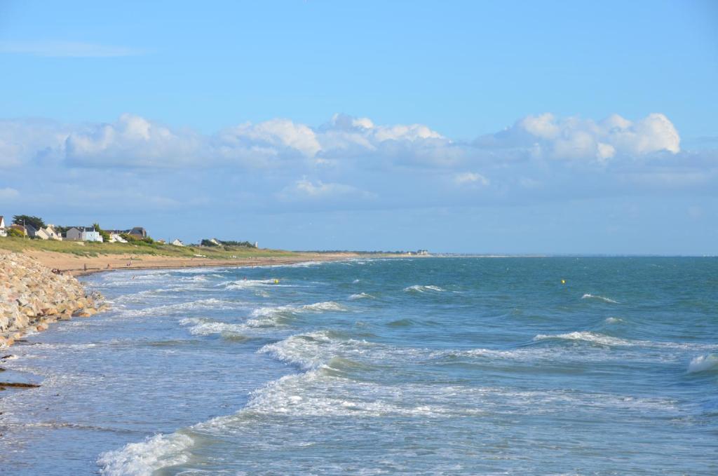 a view of the ocean with waves on a beach at Les Chambres des Gites des Isles in Barneville-Carteret