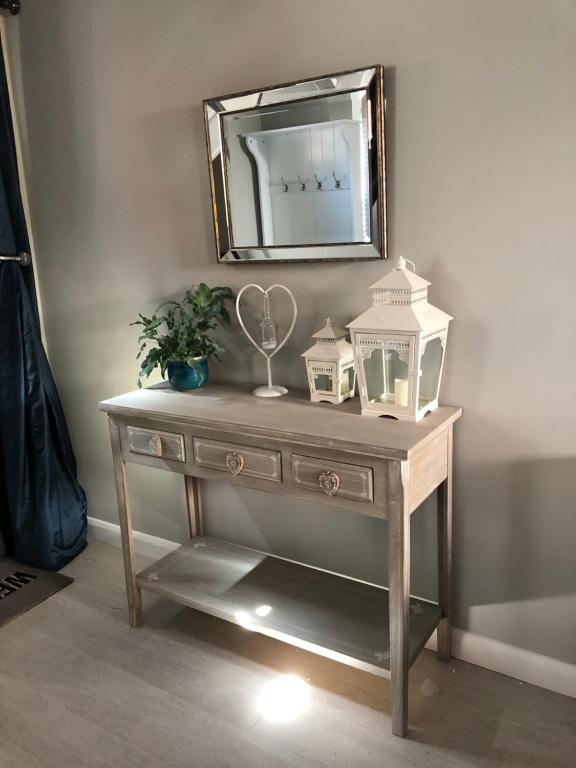 a wooden dressing table with a mirror on a wall at Boutique Townhouse in Christchurch Dorset in Christchurch