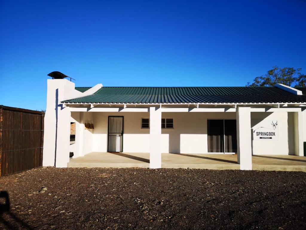 una casa bianca con il tetto verde di Kransplaas - Springbok Cottage a Adendorp