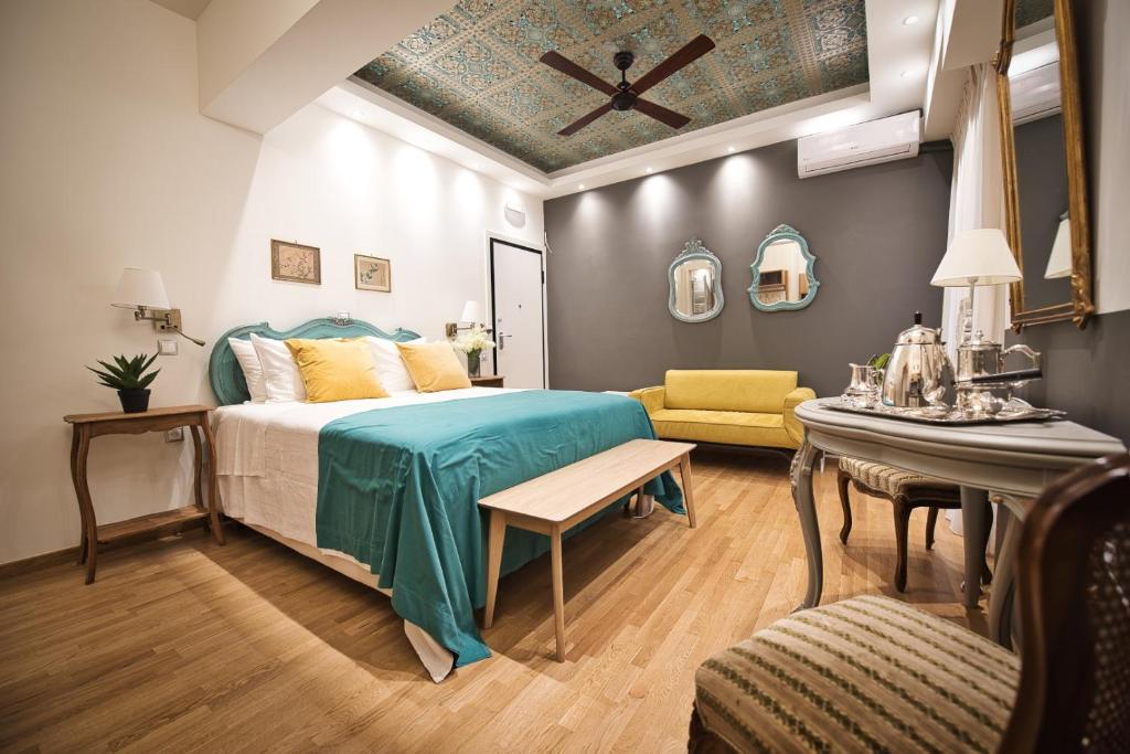 1 dormitorio con cama, mesa y sofá en Rastoni Athens Suites near Acropolis at Tsatsou street en Atenas