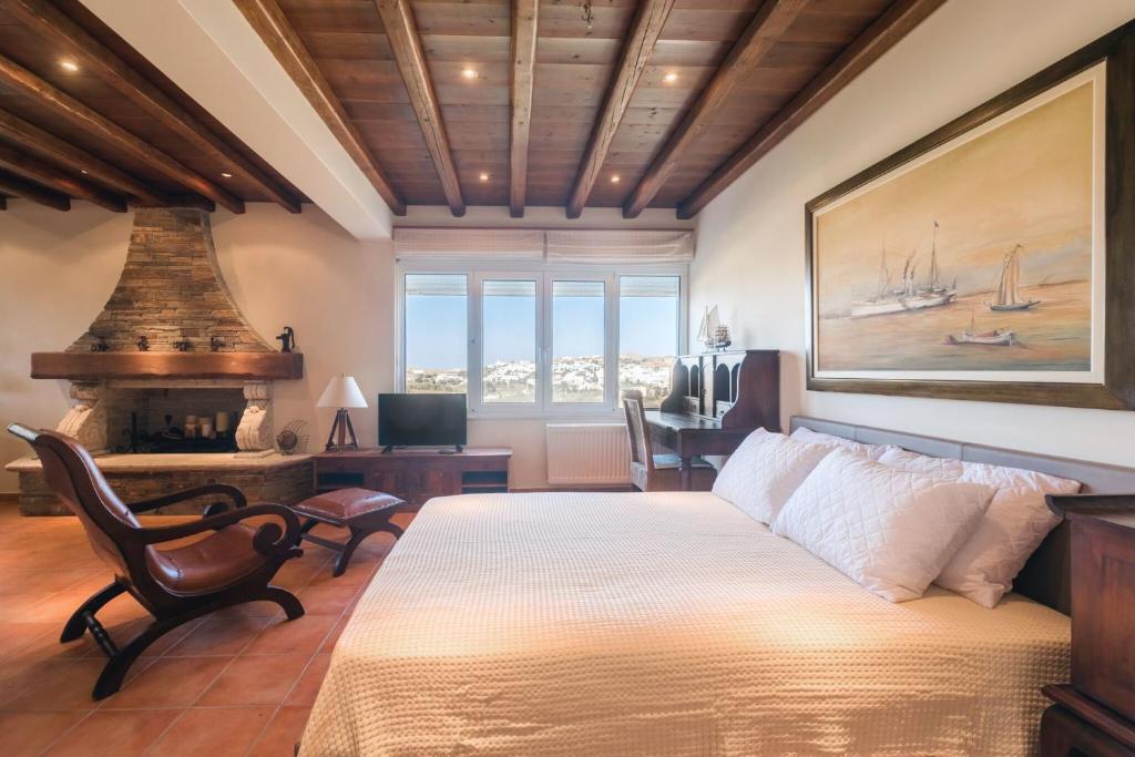 a bedroom with a large bed and a fireplace at Villa Arokaria in Stení