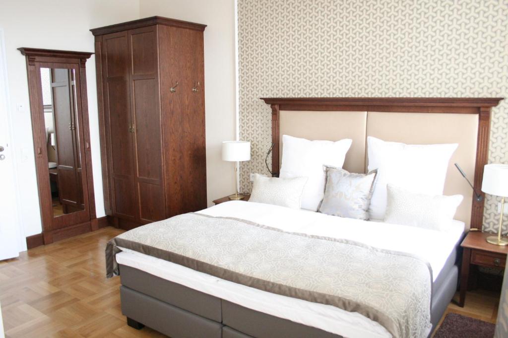 a bedroom with a large bed with a wooden headboard at Hotel Villa Altenburg in Pößneck