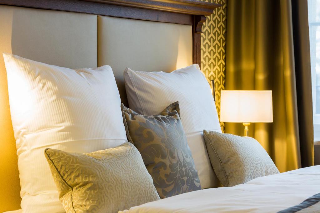 a bedroom with a bed with white pillows at Hotel Villa Altenburg in Pößneck