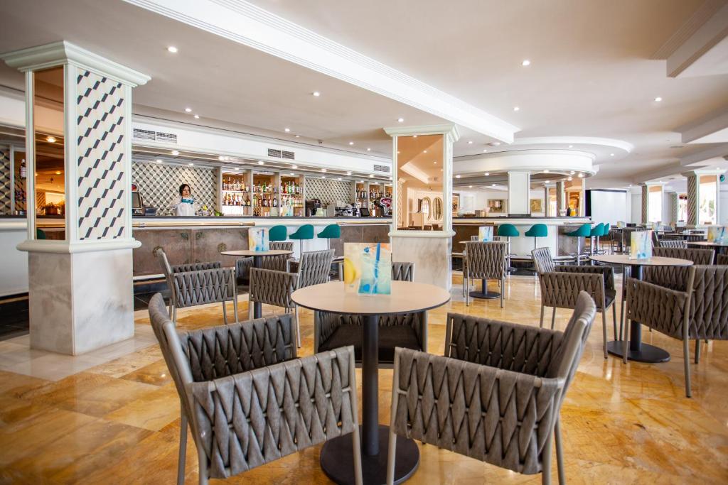 a restaurant with tables and chairs and a bar at Grupotel Los Príncipes & Spa in Playa de Muro