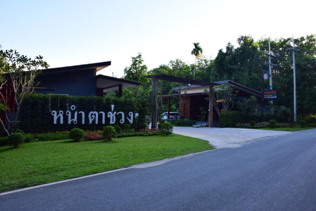a building with a sign on the side of a road at Nao Ta Chuang in Thung Song