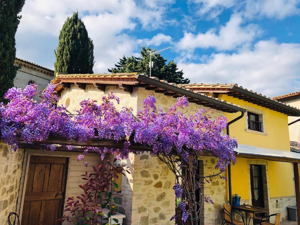 dom z fioletowymi kwiatami na boku w obiekcie Il Cortile delle Rose Holiday House w mieście Perugia