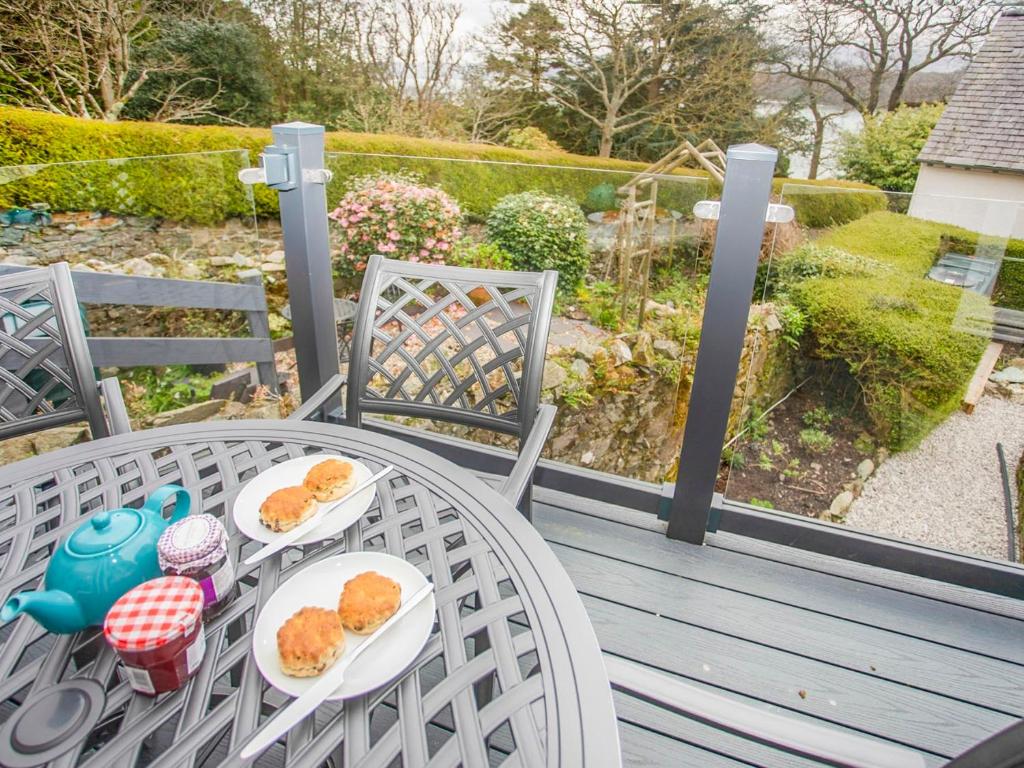 a table with two plates of donuts on a porch at Bryn Teg Cottage in Menai Bridge