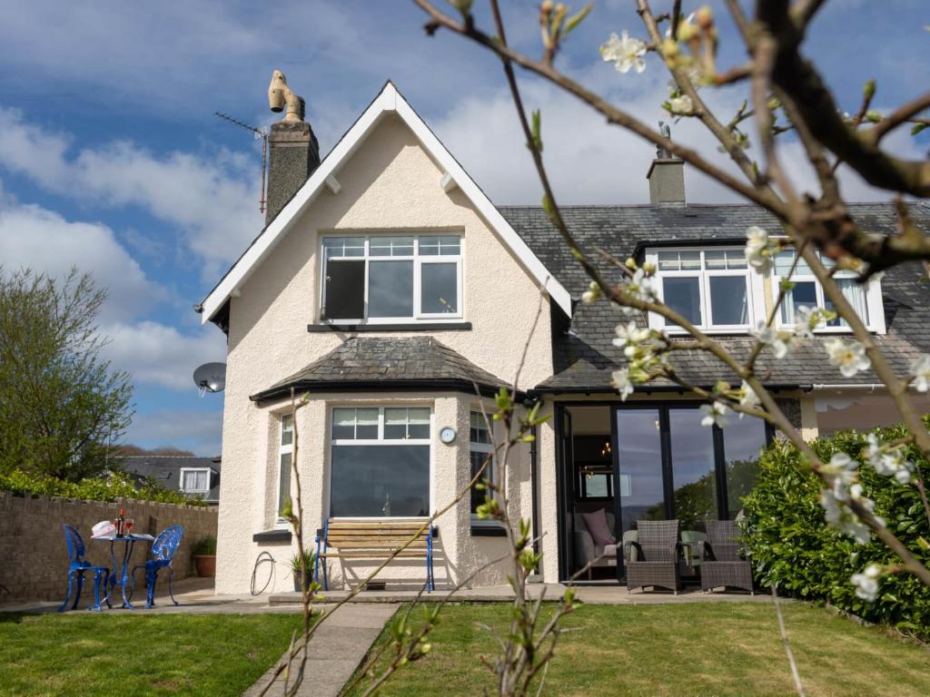 a white house with a dog on the roof at Achipur in Porthmadog