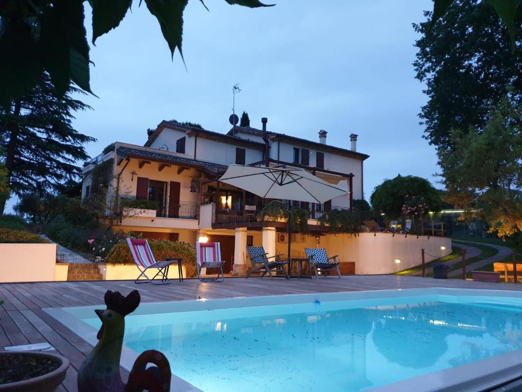 ein Haus mit einem Pool vor einem Haus in der Unterkunft CA' DEI GELSI B & B in Coriano