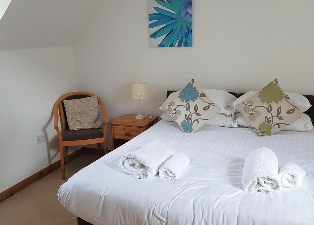 a bedroom with a white bed with towels on it at Heathfield Highland Estate in Invergordon