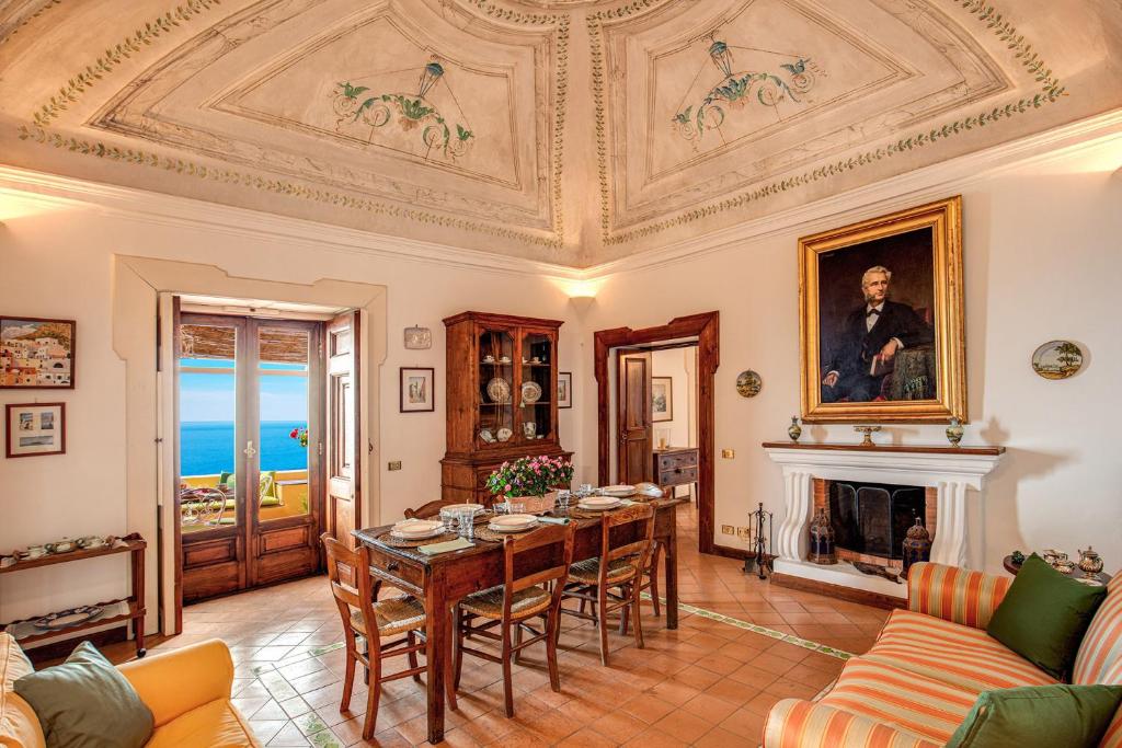 salon ze stołem i kominkiem w obiekcie Casa Marina w mieście Positano