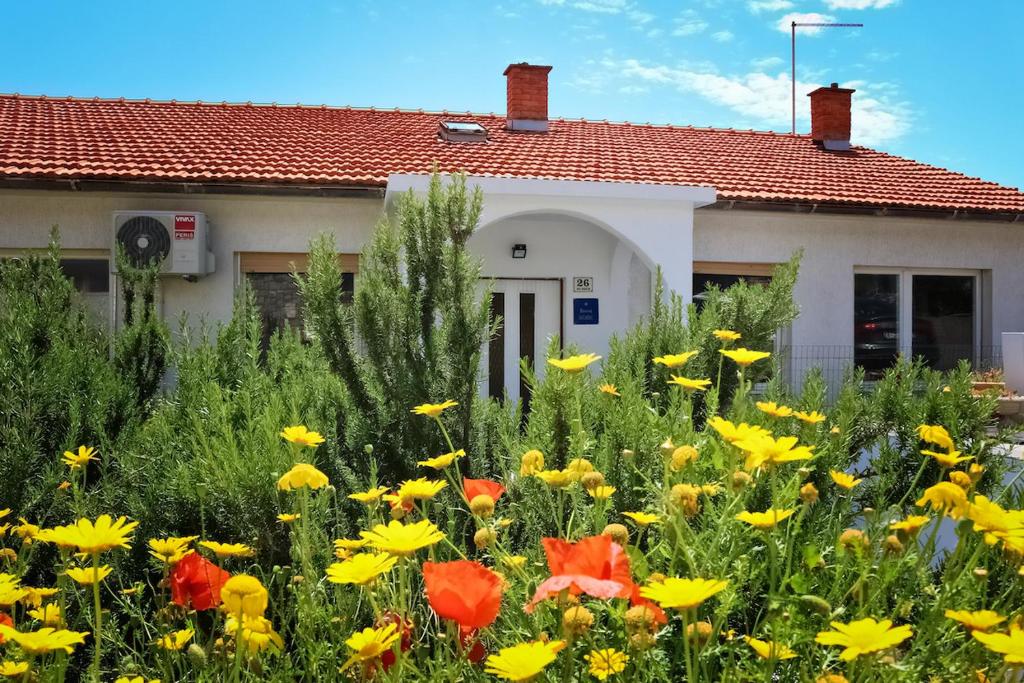 a house with a field of flowers in front of it at Rooms Hvar in Hvar