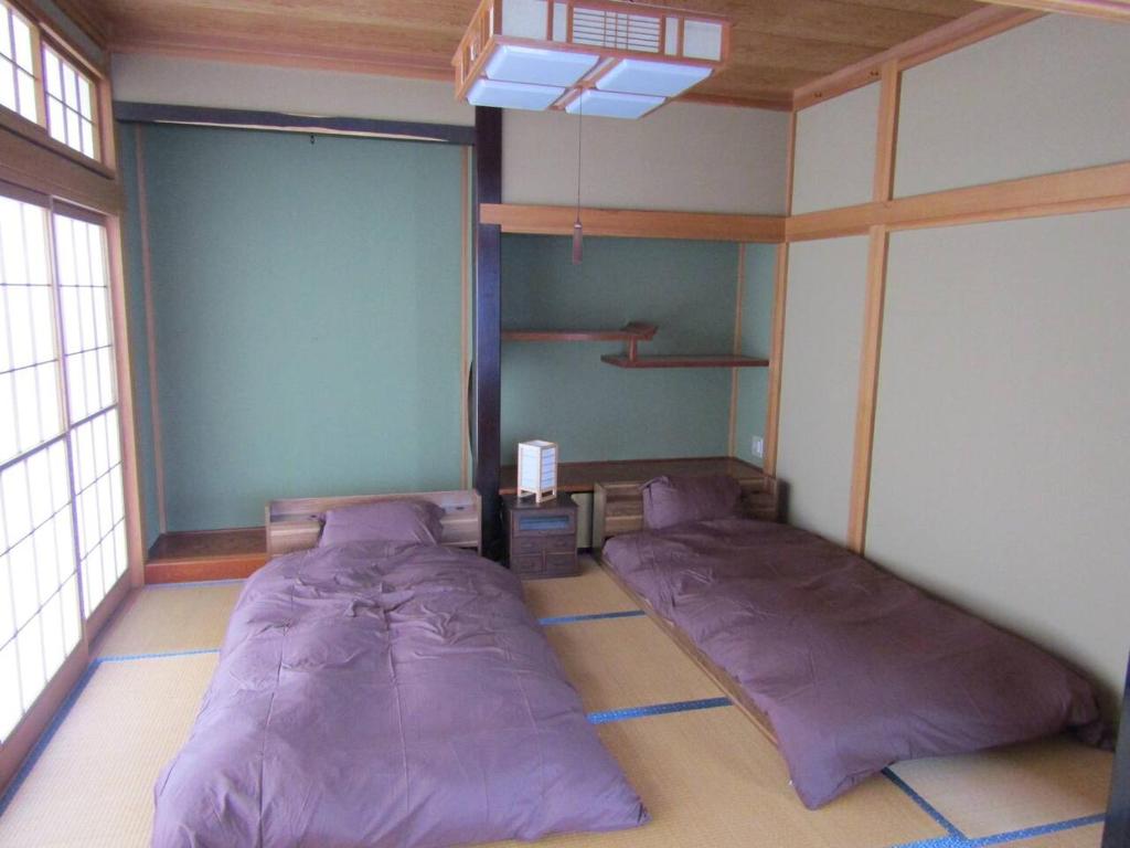 een slaapkamer met 2 bedden in de hoek van de kamer bij Yuzawa Condo 一棟貸 貴重な駐車場2台無料 in Yuzawa