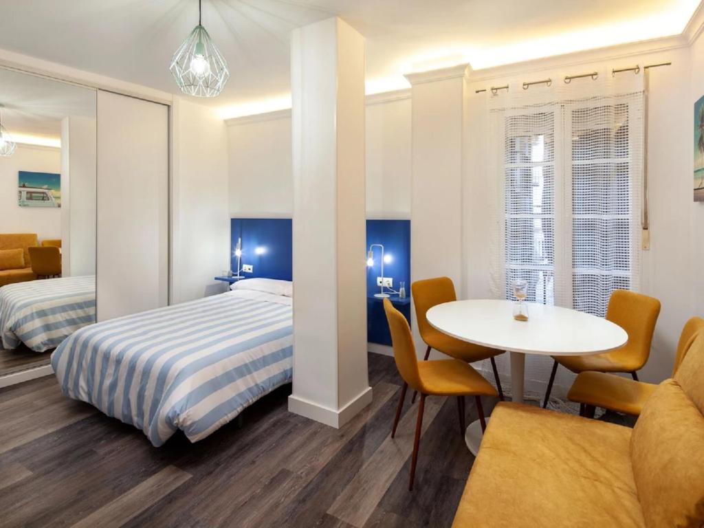 Un dormitorio con una cama y una mesa y sillas. en Duende Apartments, en Málaga