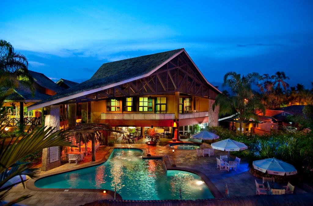 uma vista exterior de um resort com uma piscina em Ilha Flat Hotel em Ilhabela