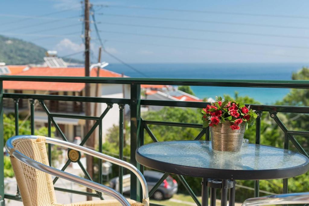 a table with a vase of flowers on a balcony at Dimitreli Venetia Studios in Koinyra