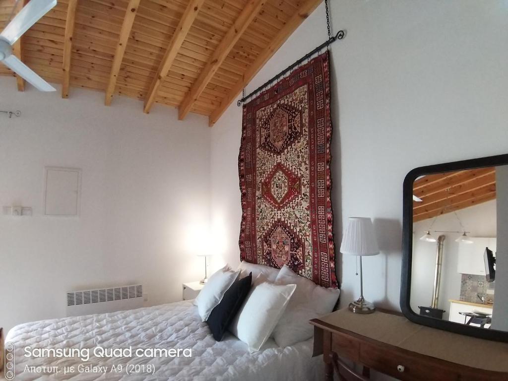 a bedroom with a bed and a large rug on the wall at Ble Mavi - Studio for 2 in Vouni