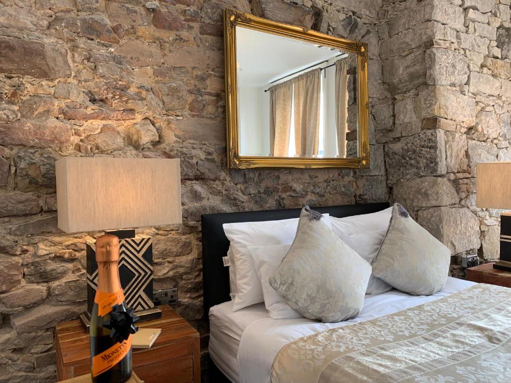 1 dormitorio con cama y espejo en la pared en Royal Mile Suites by the Castle en Edimburgo