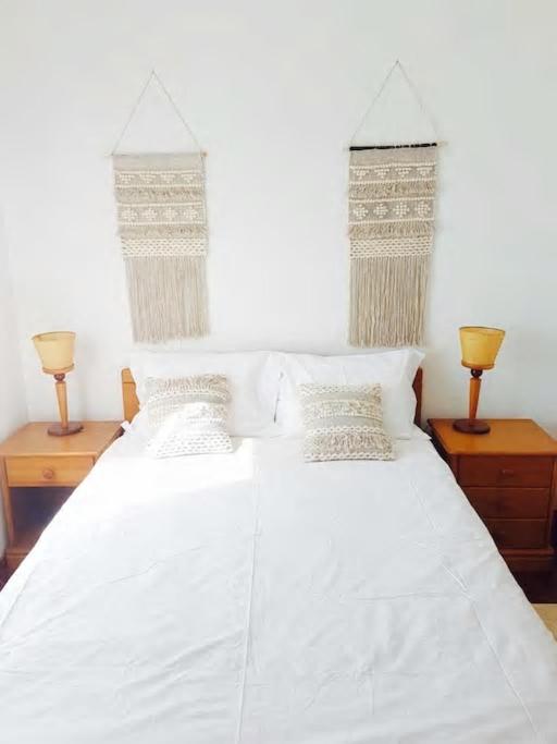 a bedroom with two beds with white sheets and two lamps at BEACH-SURF house in Moledo