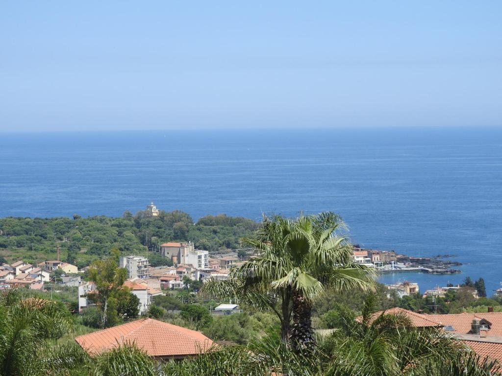 a view of a city and the ocean at Mansarda sul mare dei Ciclopi in Acitrezza