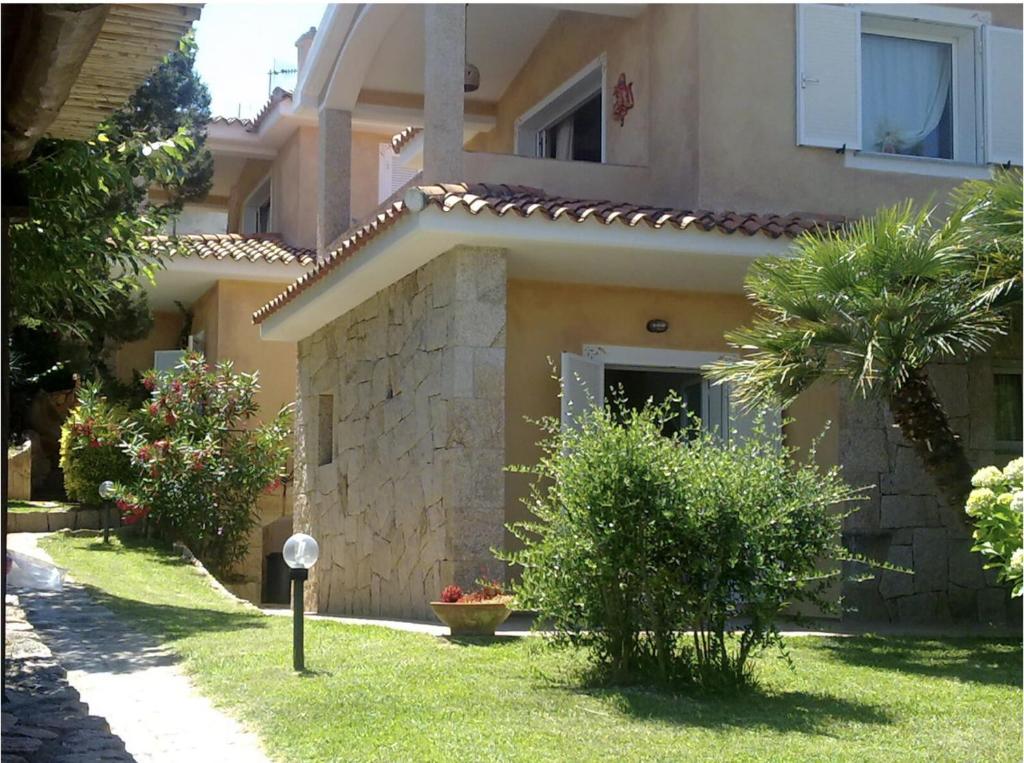 a house with a yard with trees and a building at villa PICOZZI cannigione in Cannigione