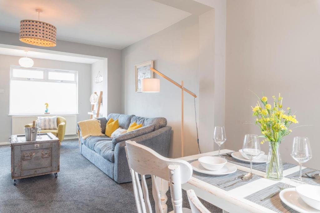 a living room with a table and a couch at Marina Beach House in Caister-on-Sea