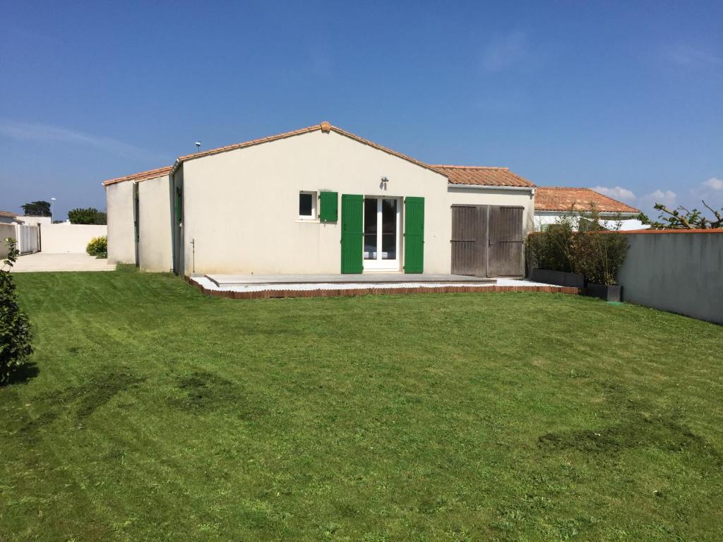 uma casa com uma porta verde e um quintal em Maison familiale La Couarde sur Mer em La Couarde-sur-Mer