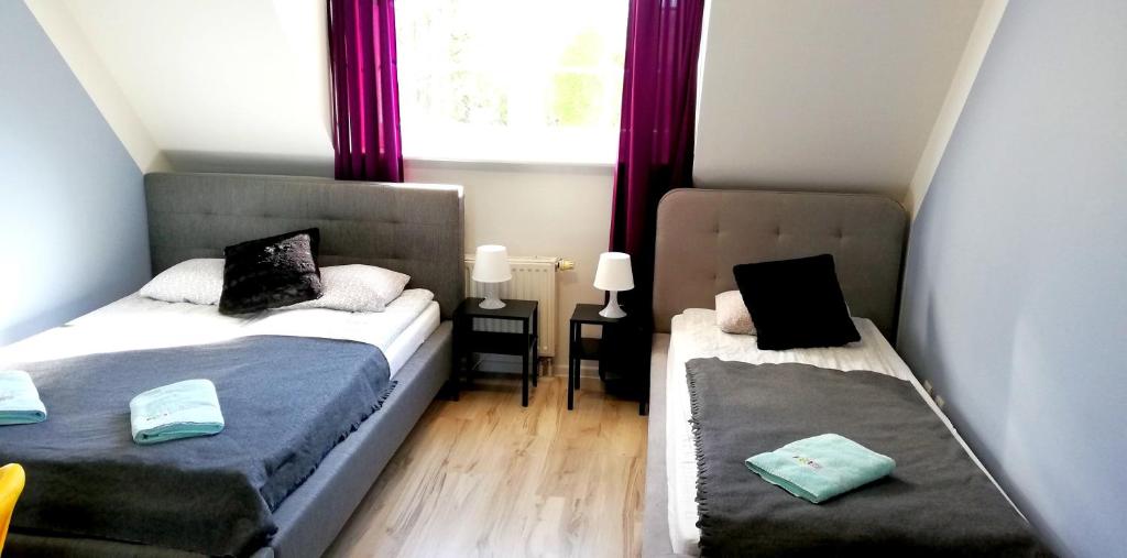 a small room with two beds and a window at Great Polonia Beach & Molo in Puck