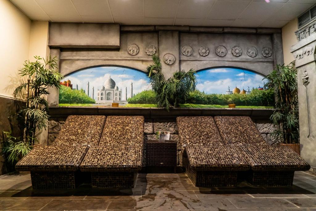 a room with three tables in front of a mural at Hotel Spa Cádiz Plaza in Cádiz