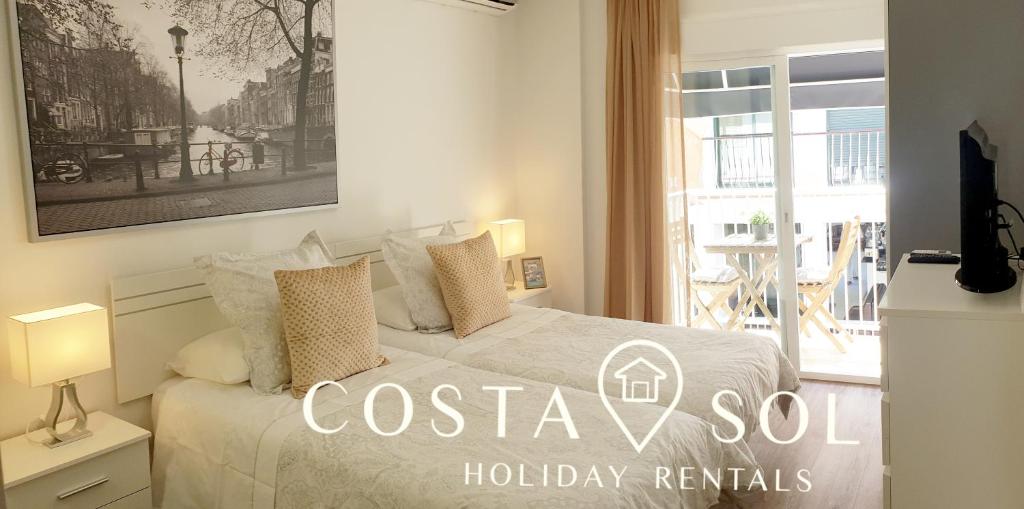 Biała sypialnia z łóżkiem i balkonem w obiekcie LA CARIHUELA TORREMOLINOS- STUDIO 1- COSTA SOL HOLIDAY RENTALS w mieście Torremolinos