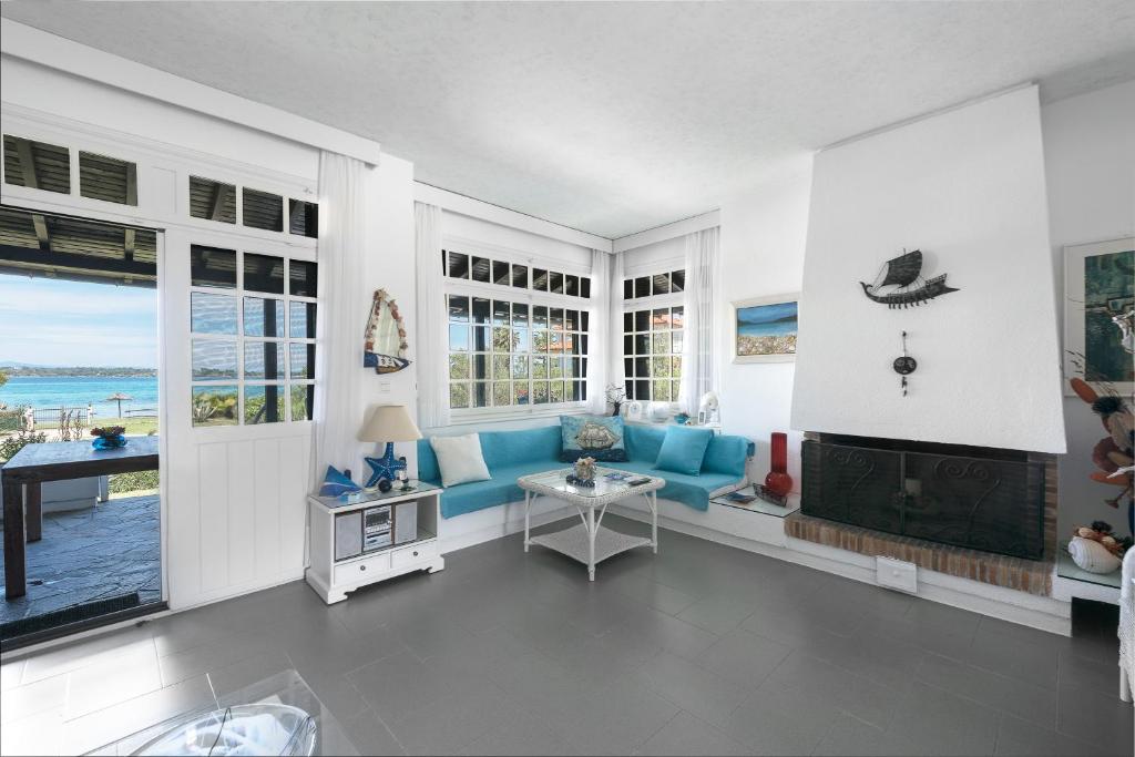 a living room with a blue couch and a fireplace at Vourvourou Villa Mare Verde by Luxlikehome in Vourvourou