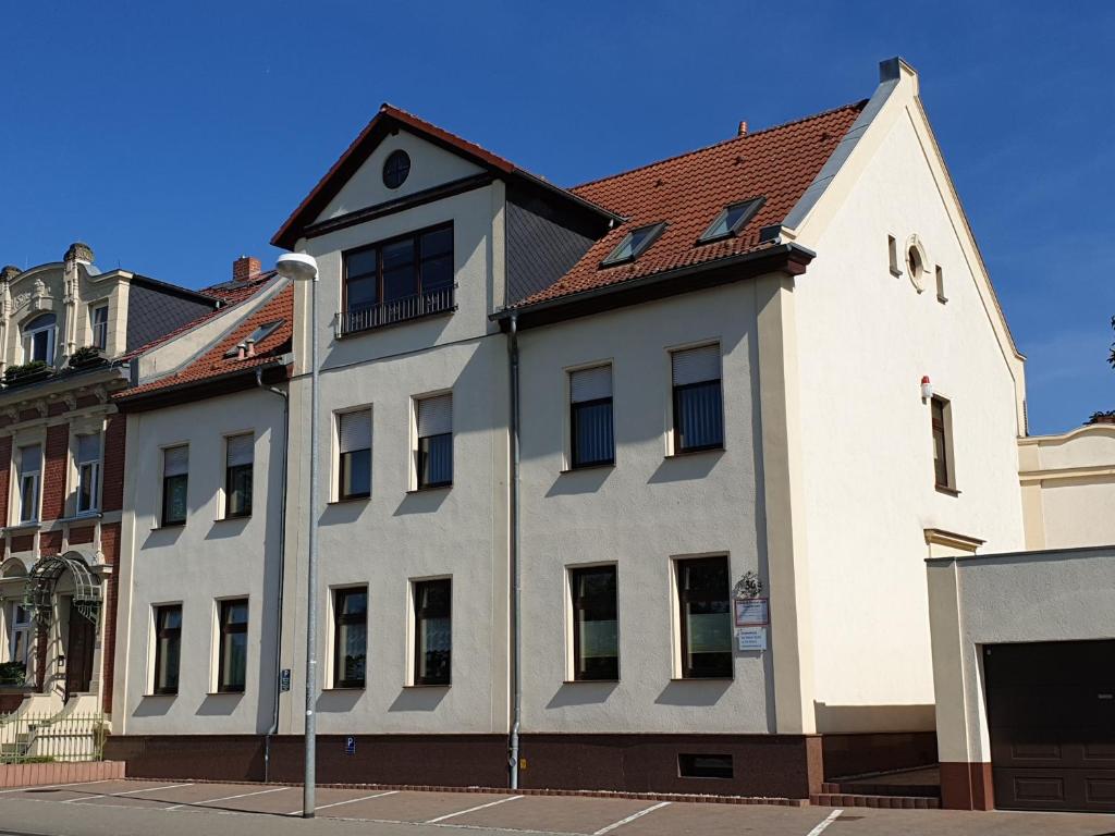 biały budynek z czerwonym dachem w obiekcie Ferienwohnung am Hohen Elbufer w mieście Coswig