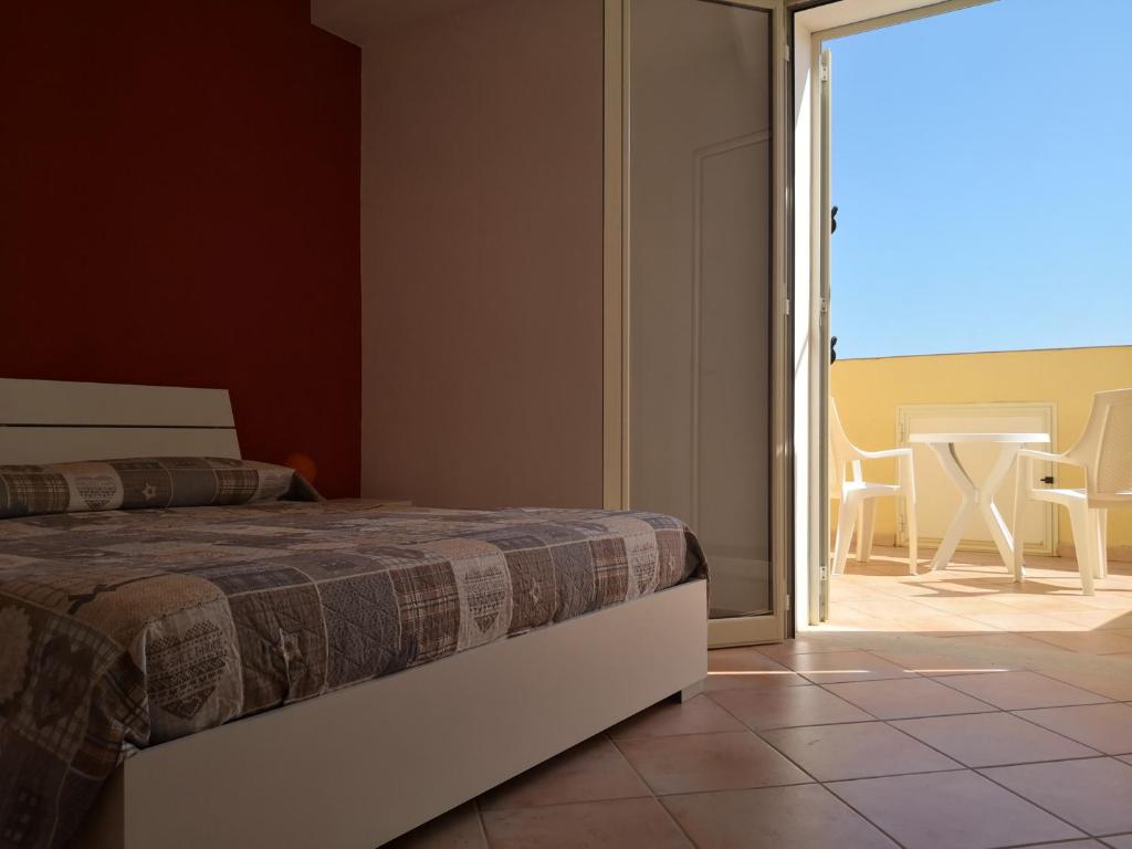 sypialnia z łóżkiem i przesuwanymi drzwiami szklanymi w obiekcie Holiday Beach Lumia w mieście Sciacca