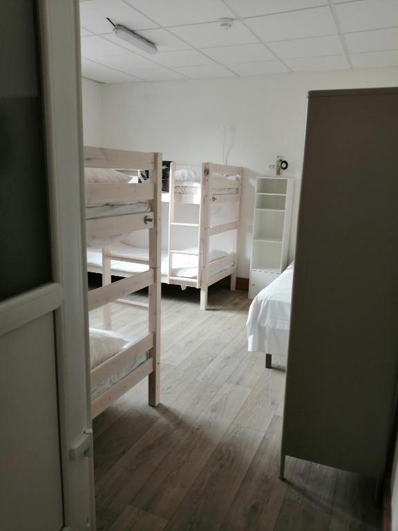 a room with several bunk beds and a mirror at Hotel de Normandie in Saint-Aubin-sur-Mer