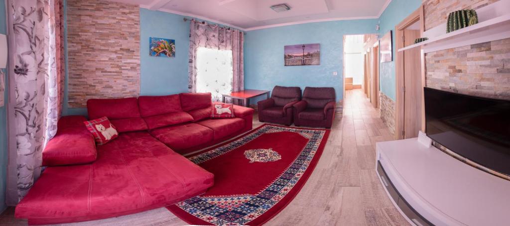 サロウにあるVilla Mariaのリビングルーム(赤いソファ、テレビ付)