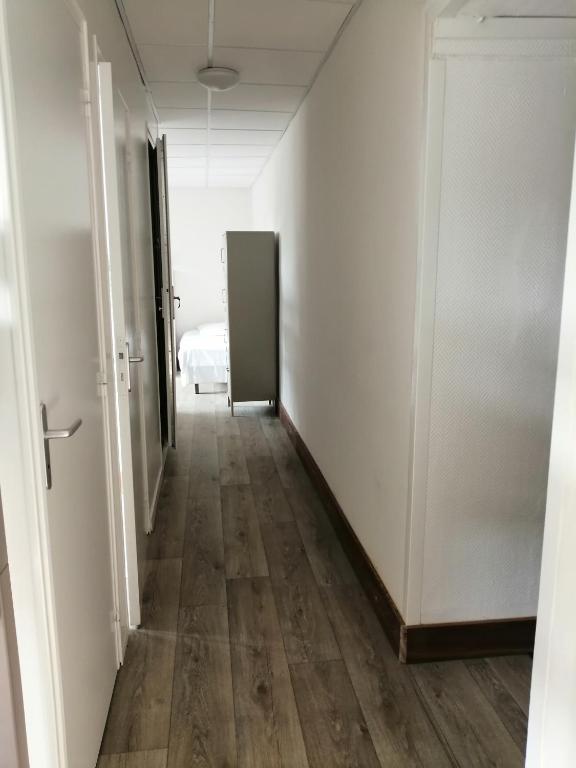 an empty hallway with a door and a room at Hotel de Normandie in Saint-Aubin-sur-Mer