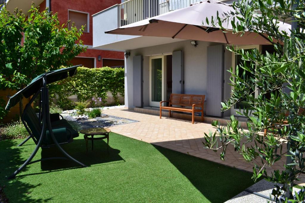 ein Garten mit Spielplatz und Sonnenschirm in der Unterkunft La Bella Italia in Desenzano del Garda