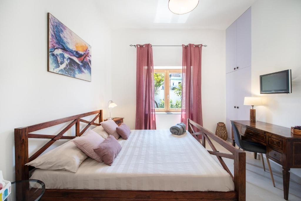 Schlafzimmer mit einem Bett, einem Schreibtisch und einem Computer in der Unterkunft B&B PROCHYTEA in Procida