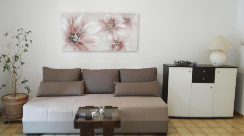 un soggiorno con divano e un dipinto sul muro di Apartman Magasic a Krk
