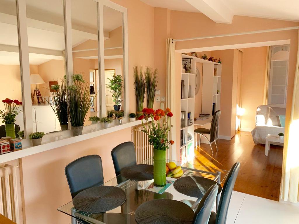 une salle à manger avec une table et des chaises en verre dans l'établissement Le Patio maison de charme 150m plage et hyper centre, à La Rochelle