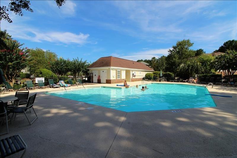 una grande piscina blu con due persone di 1113 River Crossing Condo a North Myrtle Beach