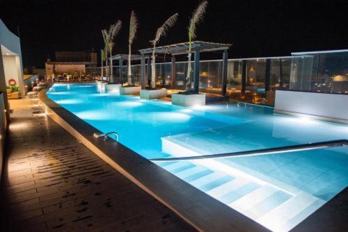 a large swimming pool with blue water at night at Apartamentos Reserva del Mar in Santa Marta