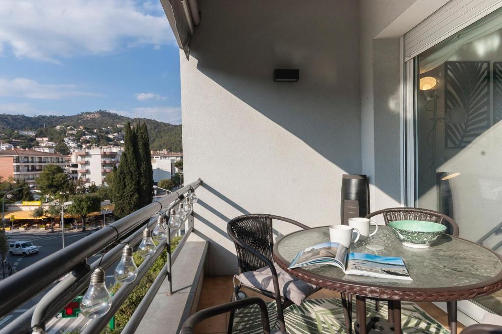 einen Balkon mit einem Tisch und Stühlen sowie Stadtblick in der Unterkunft Lets Holidays Apartment Commercial Area in Tossa de Mar