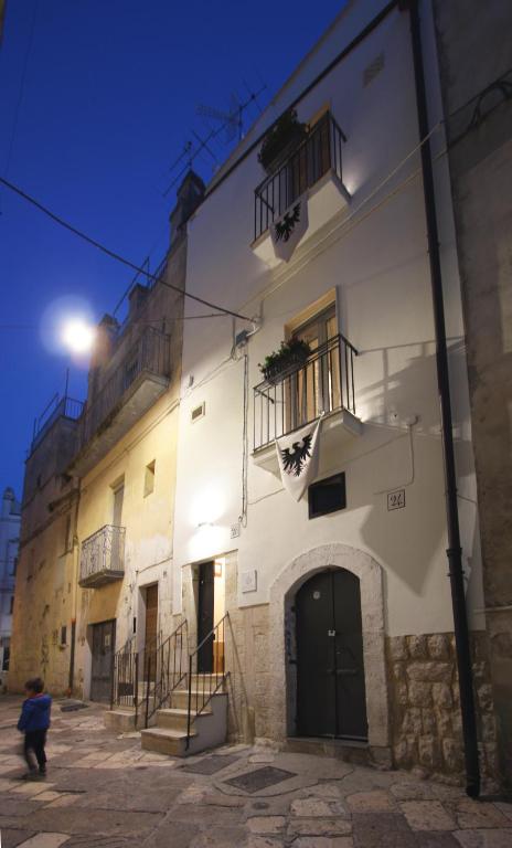 a person walking in front of a white building at B&B Santa Chiara in Altamura