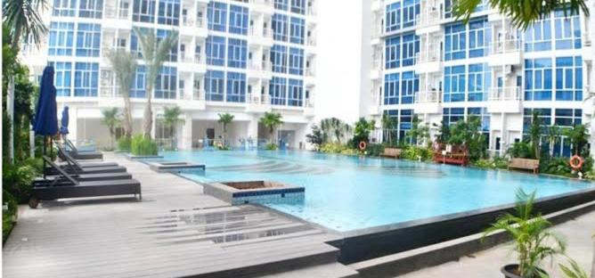 a large swimming pool in front of a building at Capitol Park Residence salemba-cozy room in Jakarta
