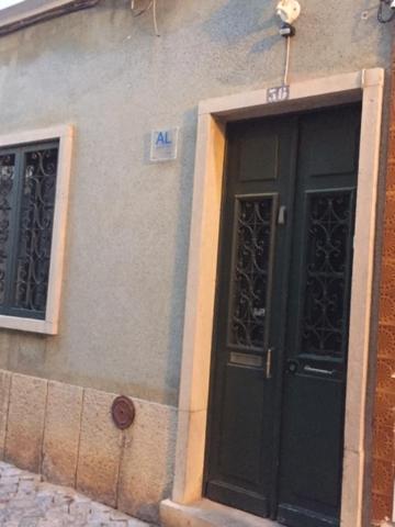 un bâtiment avec une porte noire et deux fenêtres dans l'établissement Gast House, à Faro