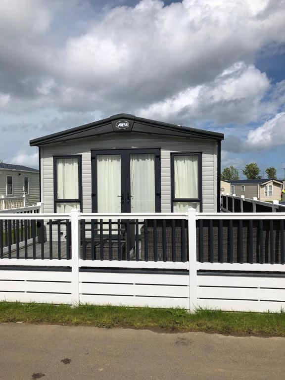 a small house with a white fence in front of it at Kent Getaways in Westgate-on-Sea